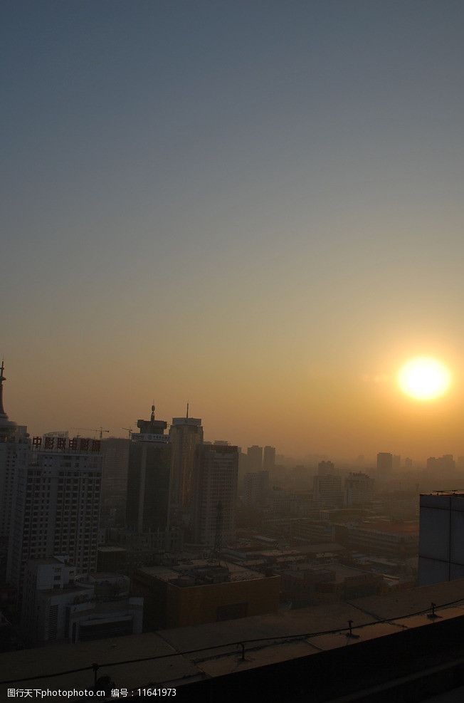 雾霾下的都市城市夕阳图片